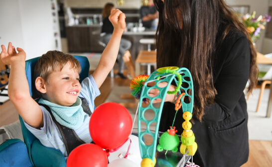 a woman and a boy playing with balloons